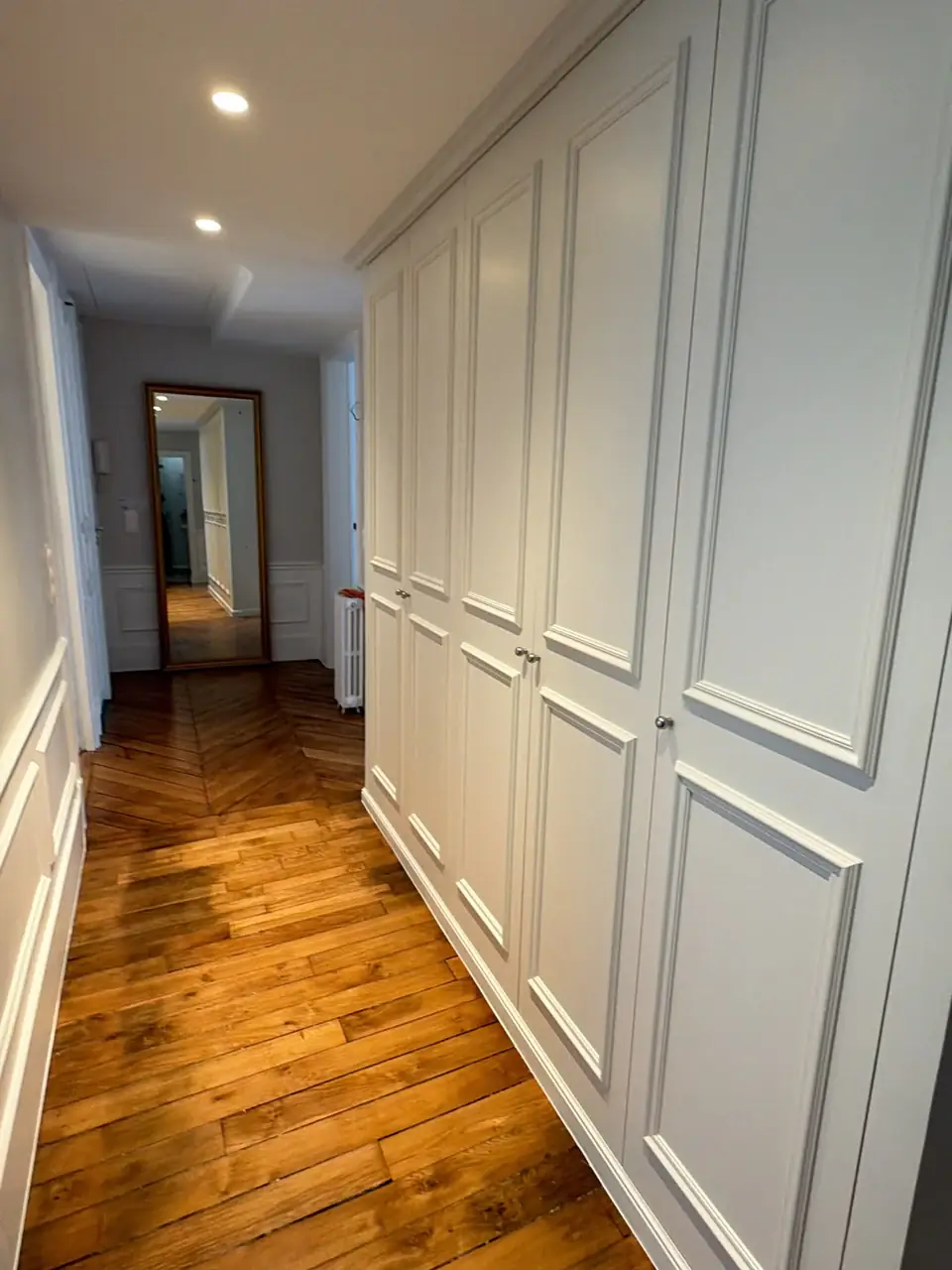 Couloir avec placards moulurés toute hauteur, soubassements et parquet ancien