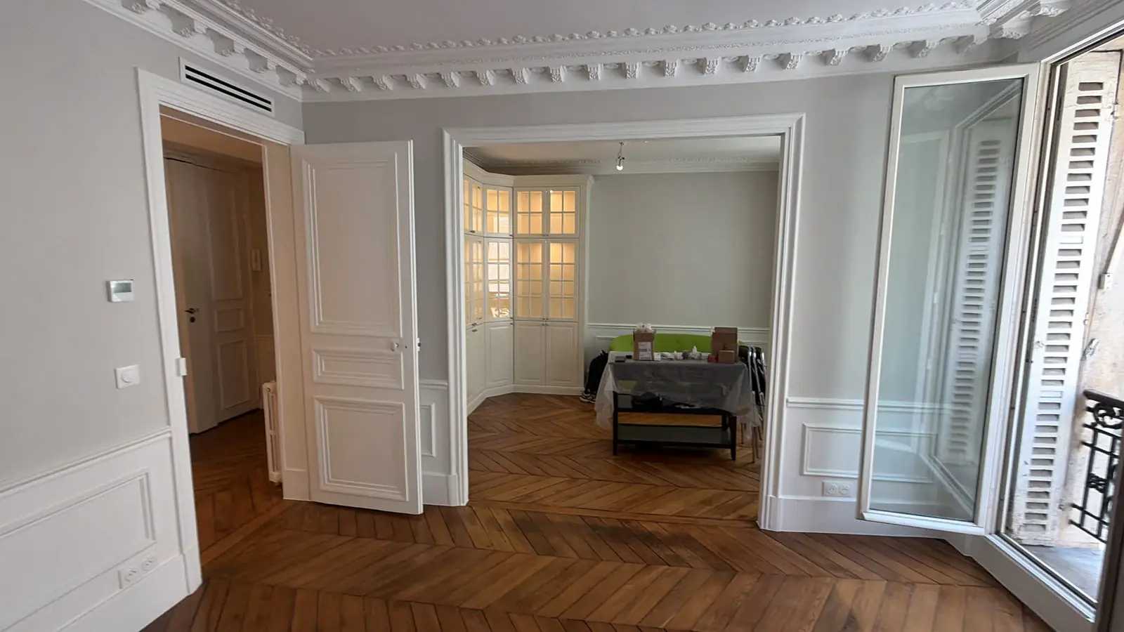 Séjour d’appartement ancien avec parquet en point de Hongrie, moulures et boiseries peintes, en fin de chantier