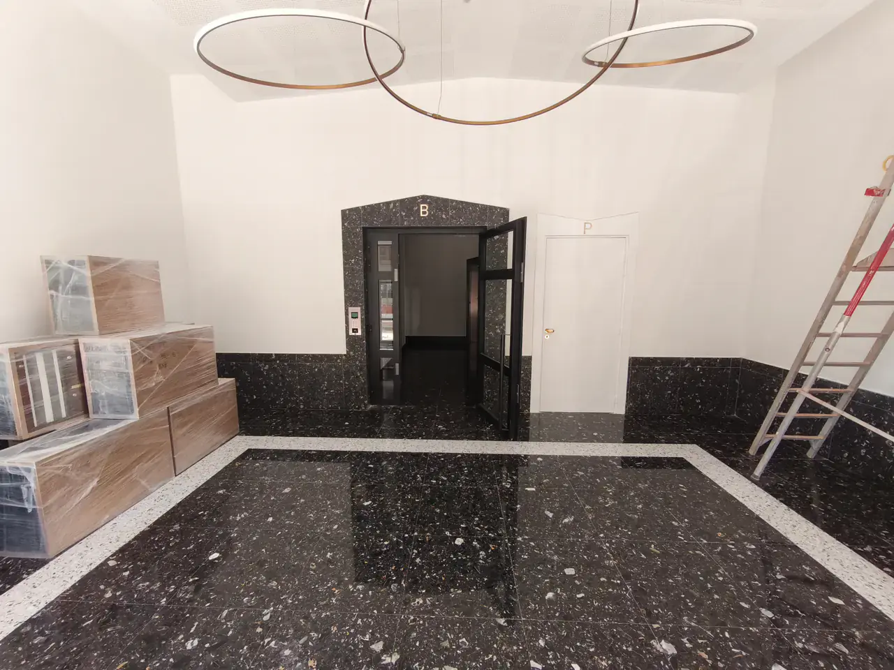 Éclairage et finitions en cours de pose dans un hall de résidence