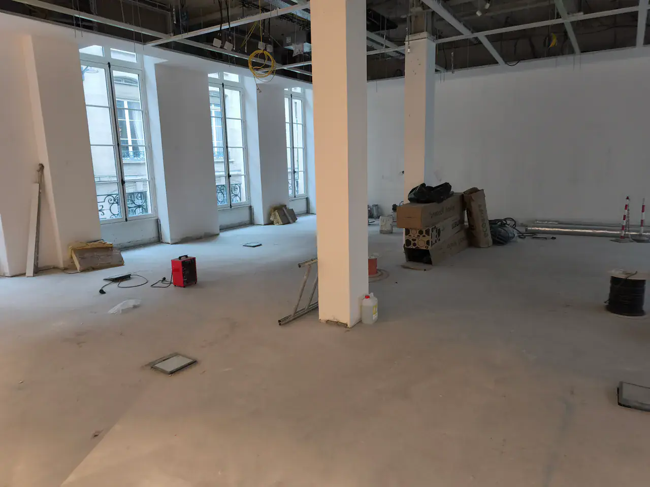 Plateau professionnel vide en chantier avec faux plafond ouvert et câbles en attente