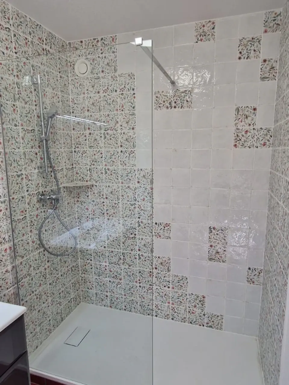 Grande douche ouverte avec receveur blanc et faïence à motifs fleuris
