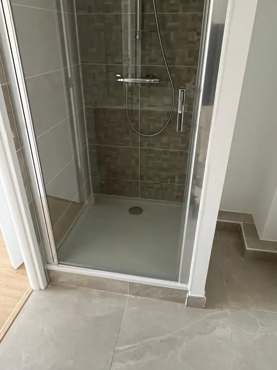 Cabine de douche vitrée avec receveur extra-plat et faïence à motif tressé