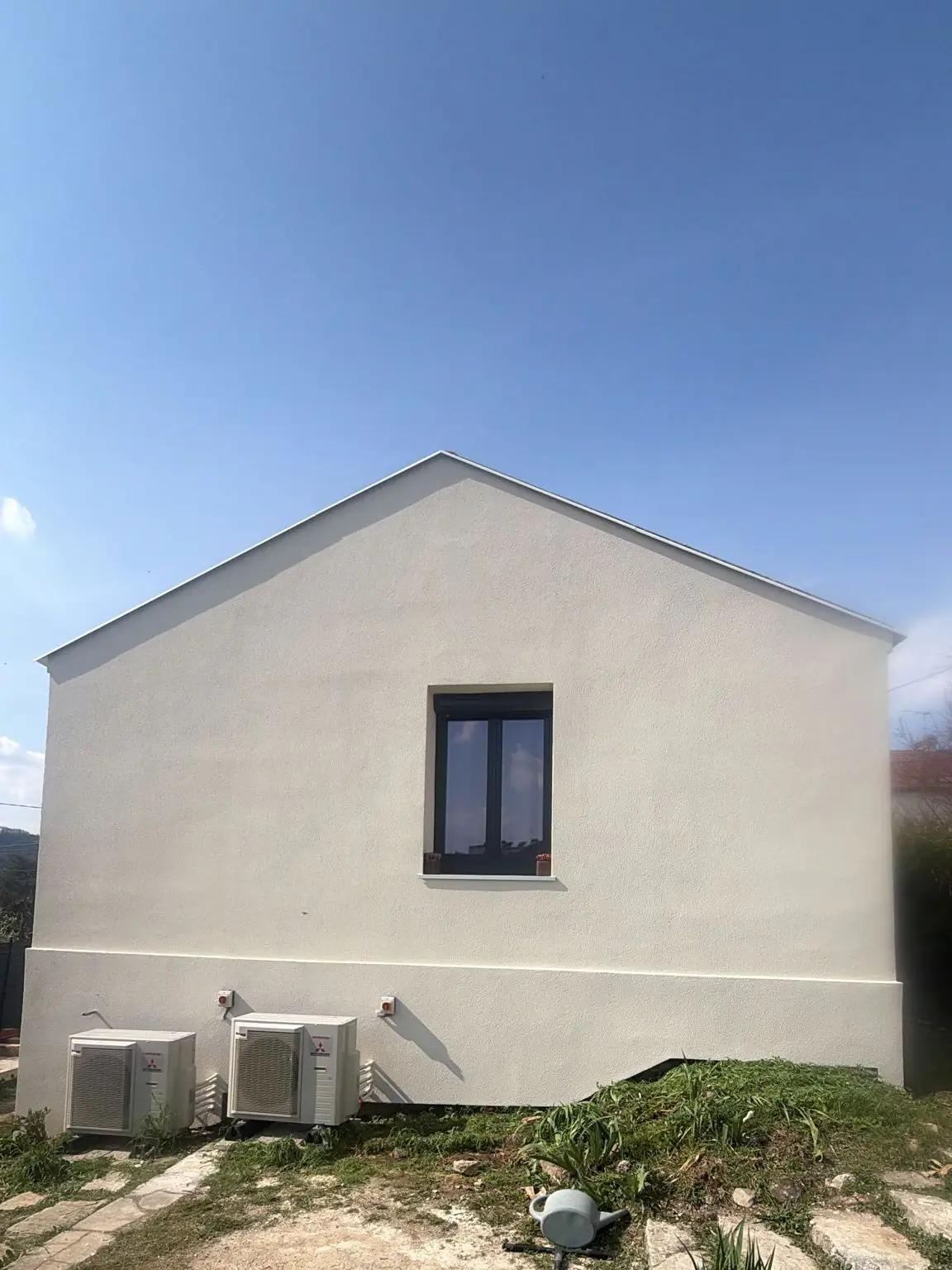 Pignon de maison isolé par l’extérieur et recouvert d’un enduit clair